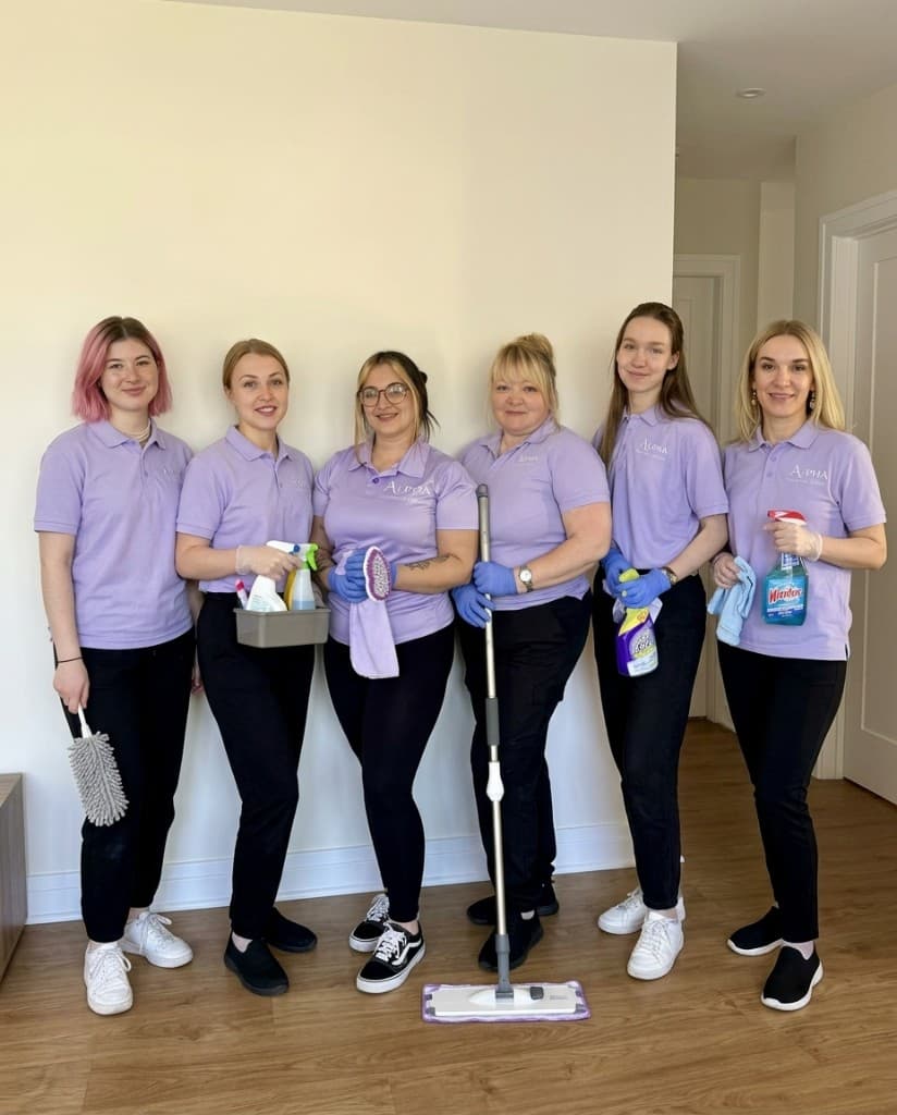 The Alpha Cleaning Agency team — six cleaners in lavender uniforms with their supplies