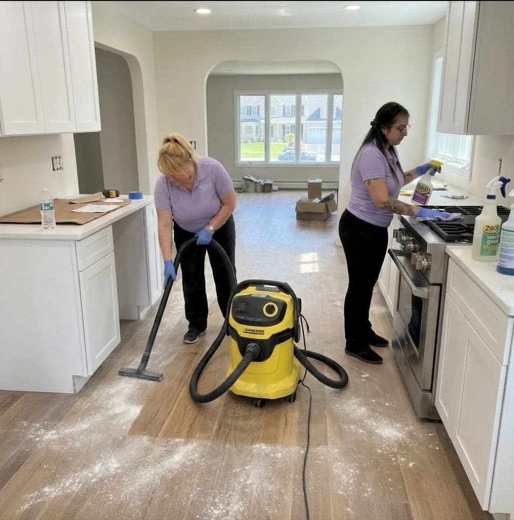 Alpha Cleaning Agency team HEPA-vacuuming drywall dust and wiping a kitchen after a Western New York renovation.